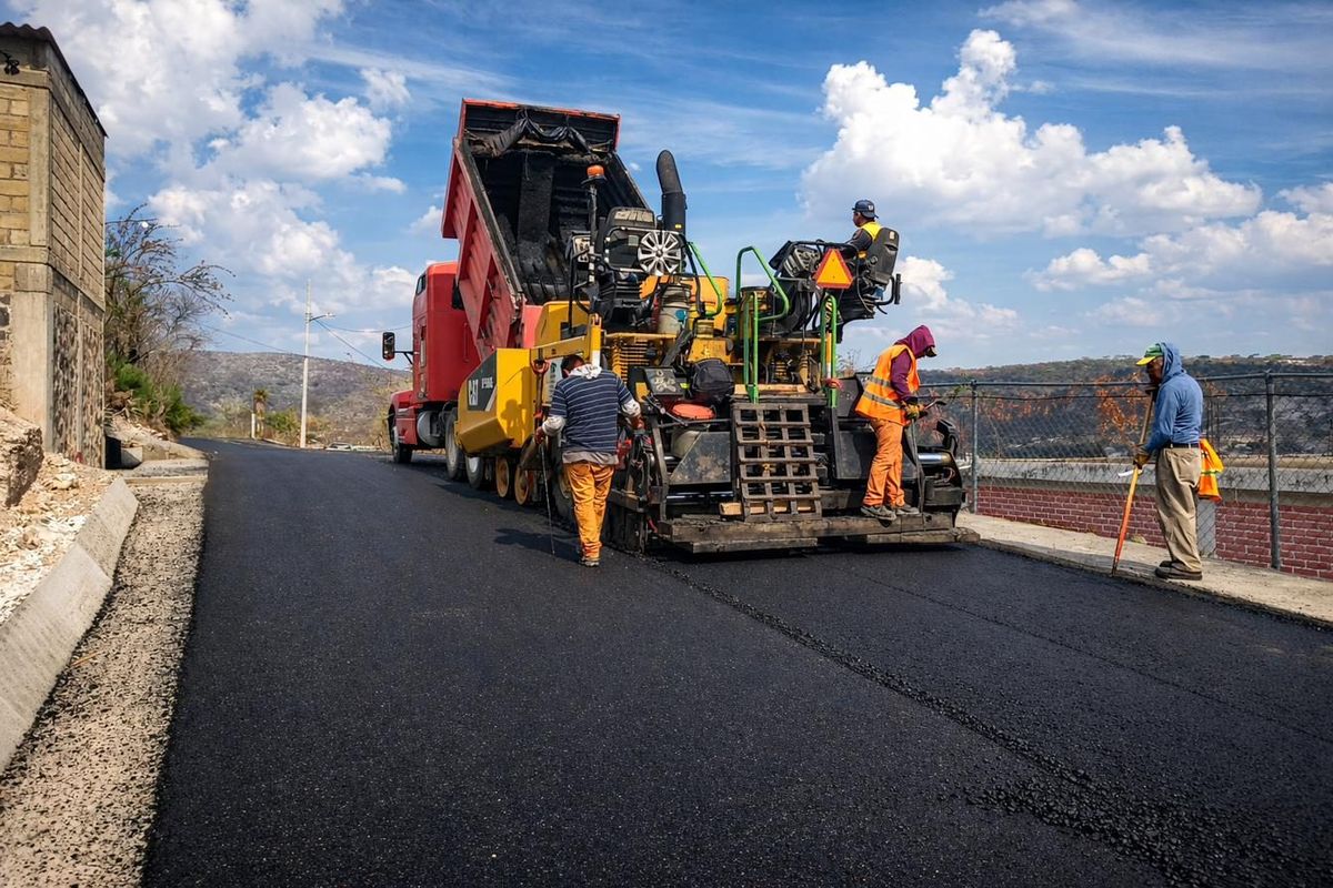 Pavimentadora y cuadrilla colocando carpeta asfáltica en vialidad urbana
